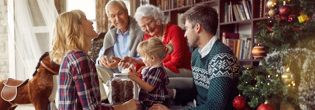 A family of different generations gathered at Christmas, showing how to talk to children at Christmas about grief through shared moments.